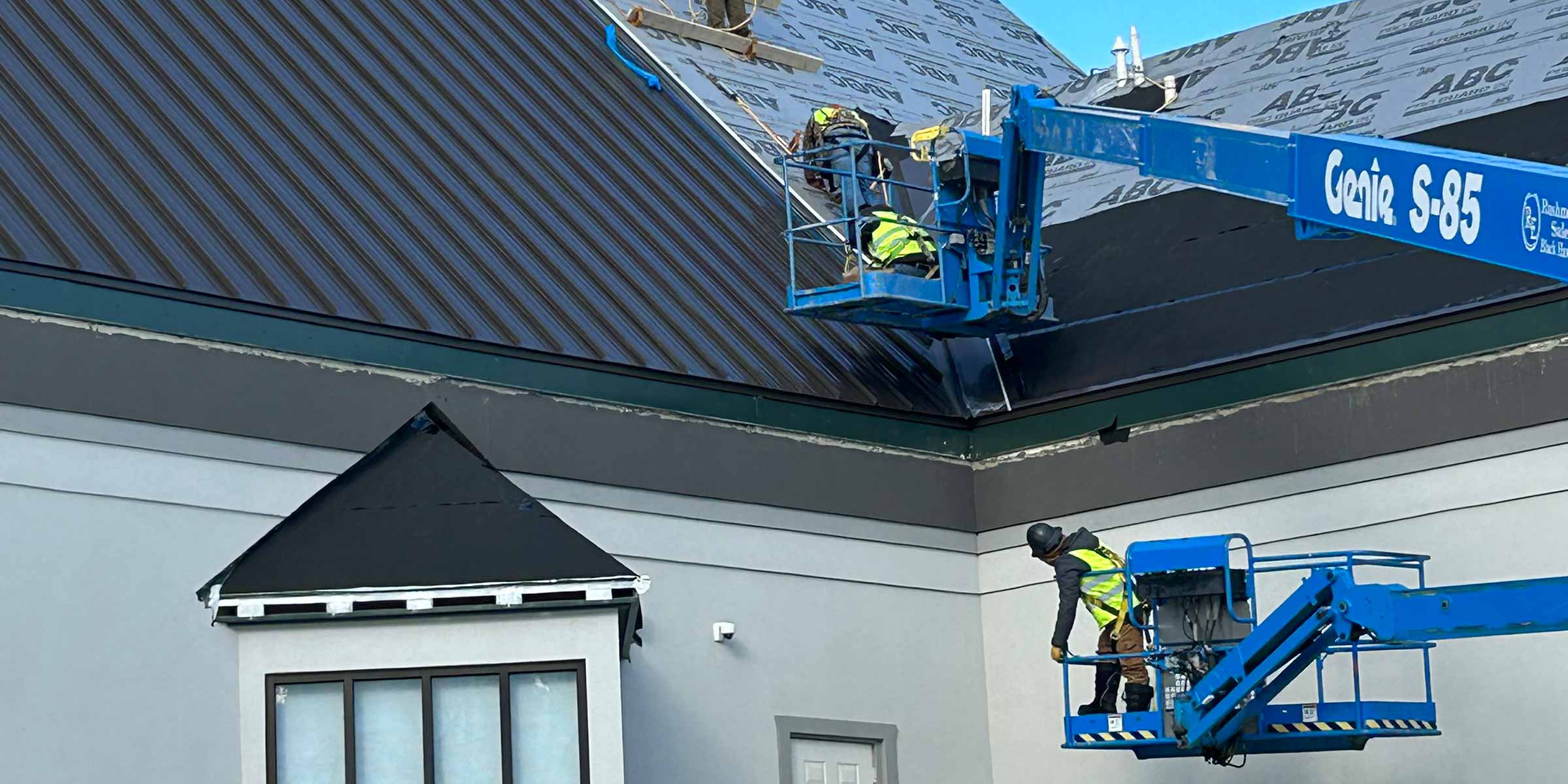 workers on a lift to repair roof