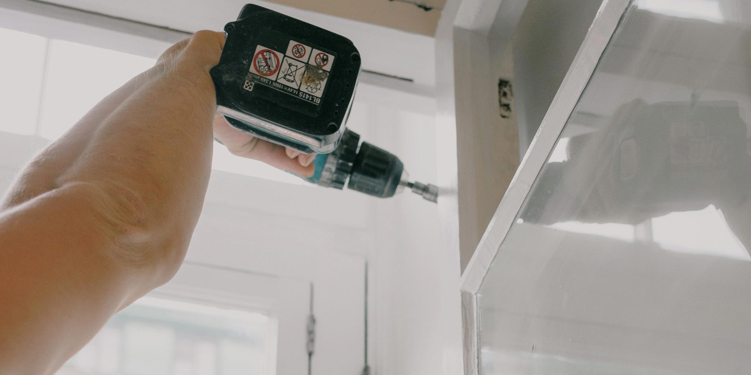 man installing window with drill